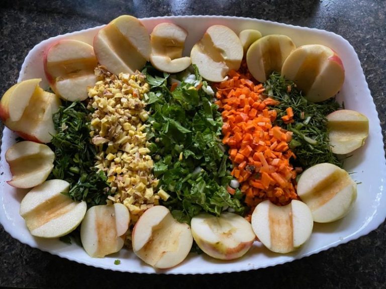 ニワトリ用のカラフルなトリート。刻んだ野菜とりんごが並べられたお皿。