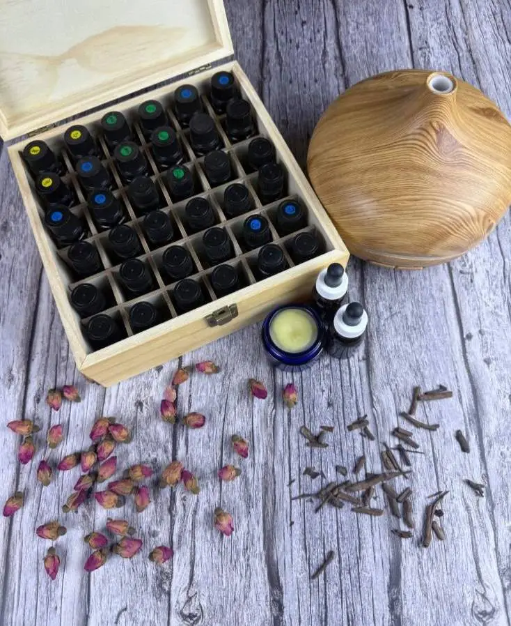 木製ボックスに収納されたエッセンシャルオイルとディフューザー、ハーブやバームが並ぶ、ウェルネスを感じるナチュラルな風景