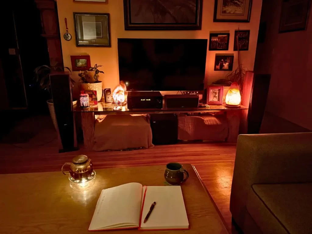 ハーブティーとノートが置かれた、眠る前のやさしい夜の時間