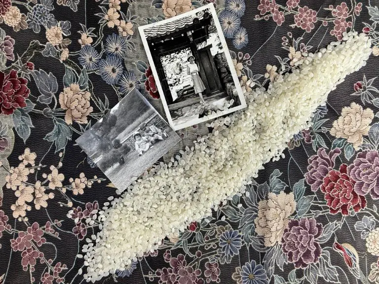 「残さず食べることと腹八分」の象徴。花柄の布の上に広がる白米と、戦時中の母の思い出が詰まった写真。