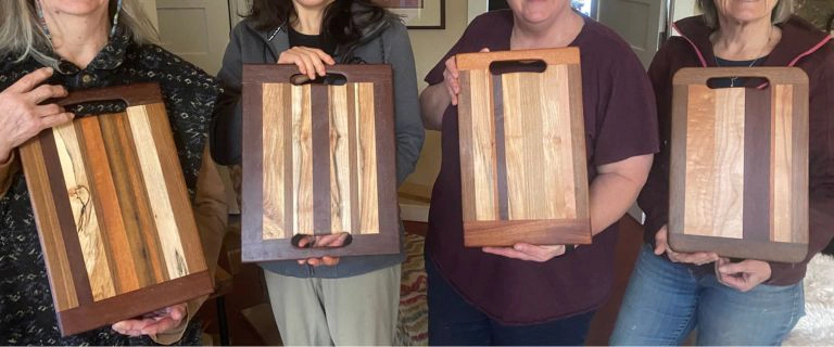 完成したまな板と参加者の記念写真 木工ワークショップで完成したまな板を手にする参加者たち