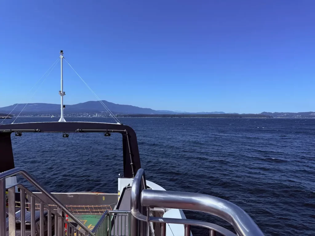フェリーのデッキから見える海と青空、遠くに山並み