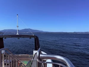 フェリーのデッキから見える海と青空、遠くに山並み